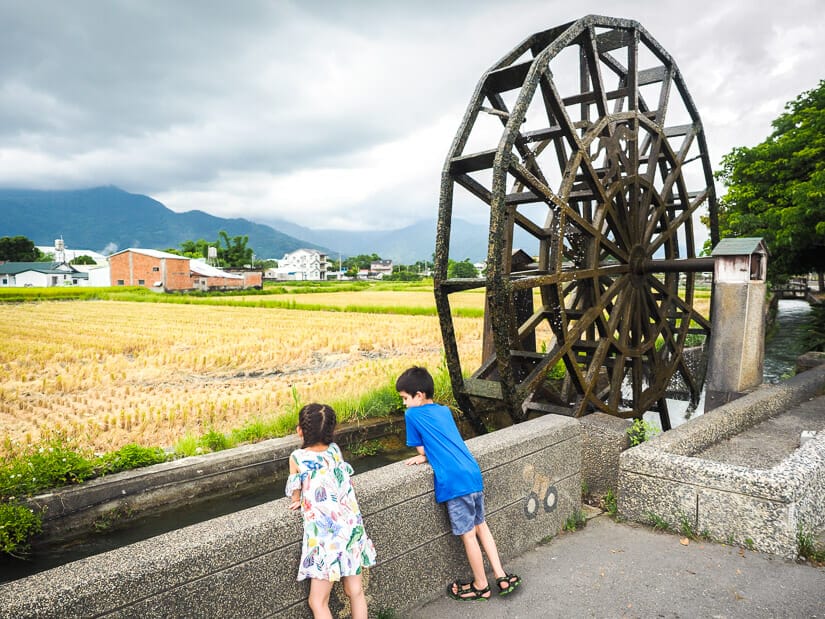 Two kids standing in front of Chishang Huge Waterwheel