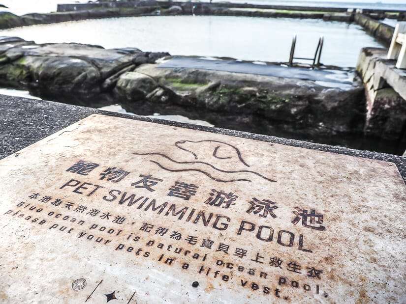 A close up of a sign that says "Pet Swimming Pool" at Keelung's Heping Island Park, with the pool in the background
