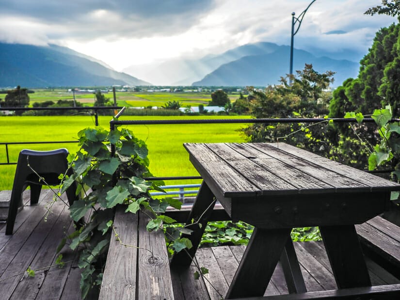 A picnic table with a view of rice paddies in Chishang and rays of light shining down through the clouds