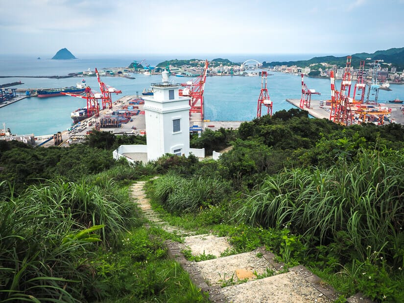 View of a stone trail leading down to Qiuzishan Lighthouse, with a view of Keelung Port in the background