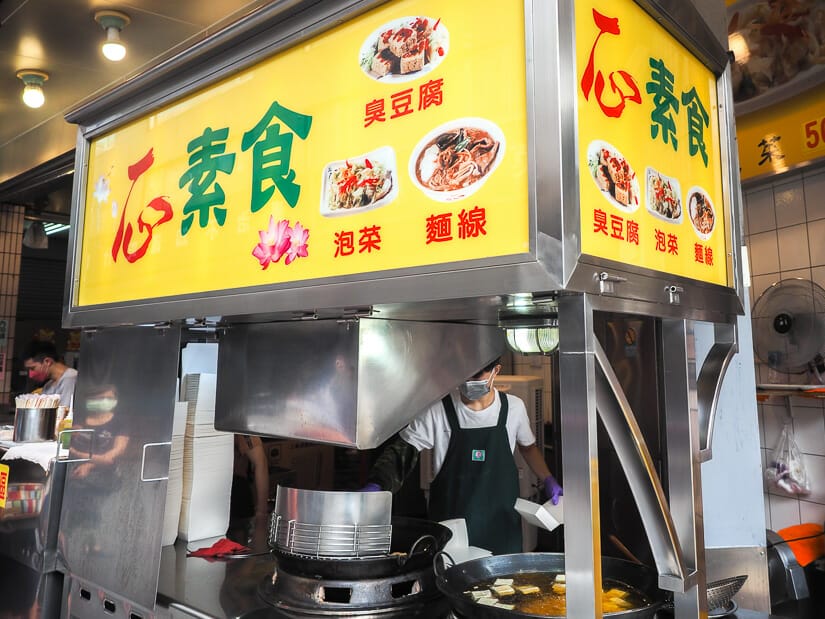 A food vendor frying vegetarian stinky tofu inside Feng Chia Night Market