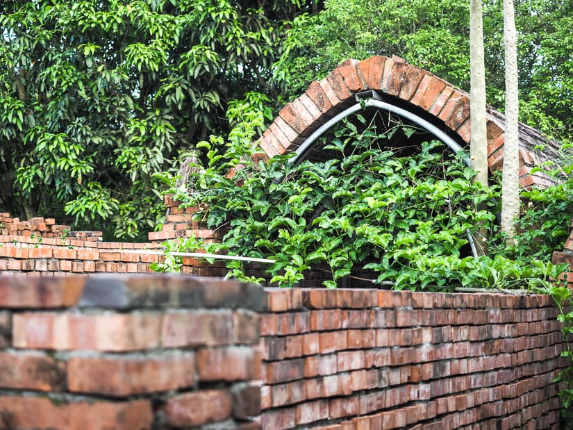 An old red brick kiln overgrown with vegetation