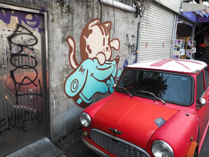 A tiny red British car and cat/dog graffiti in Yizhong Street Night Market