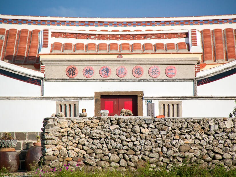 A traditional taiwanese home on Penghu with a wall of coral in front of it at Erkan Historic Village