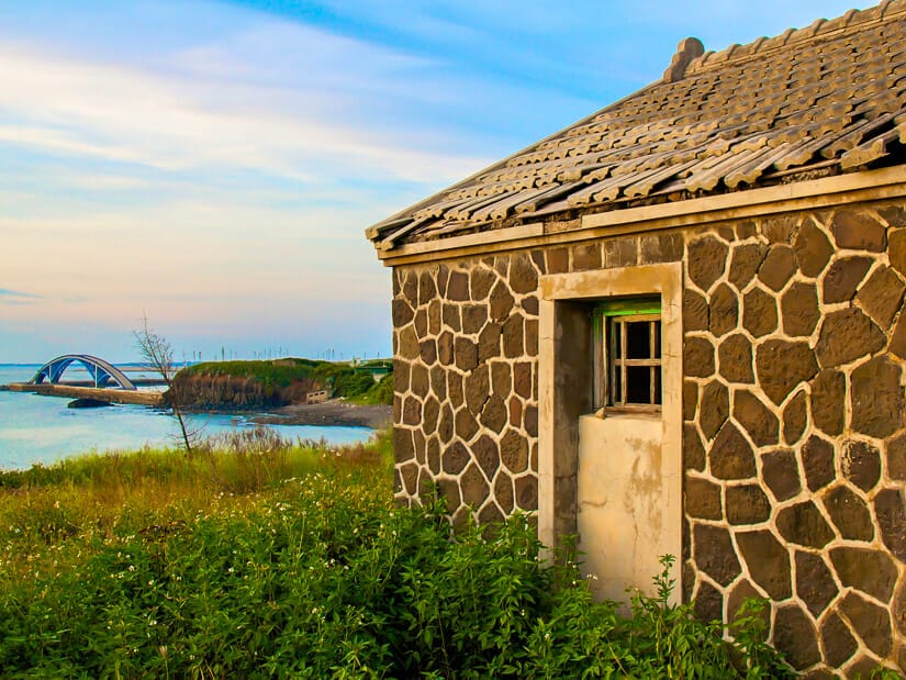 An old military house called Juguang New Village just outside of Magong in Penghu, with Rainbow Bridge in the background