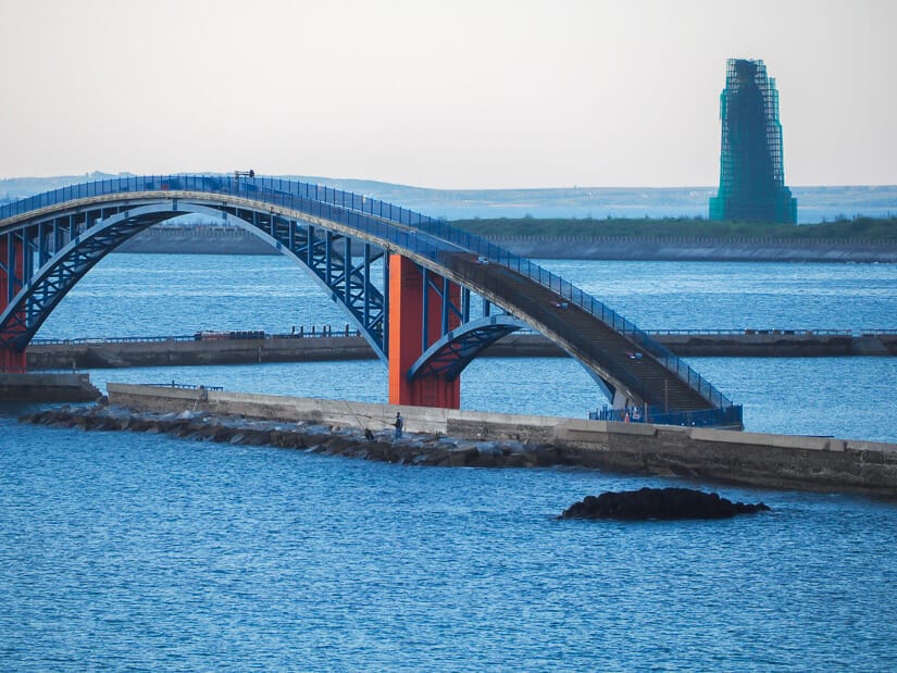 Rainbow Bridge in Penghu with an almost complete giant Matsu Statue behind it