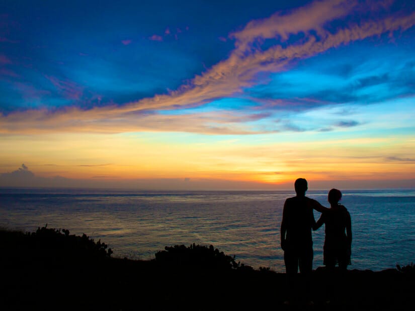 The silhouette of a brother and sister watching the sunset over the sea at Yuwengdao lighthouse Penghu