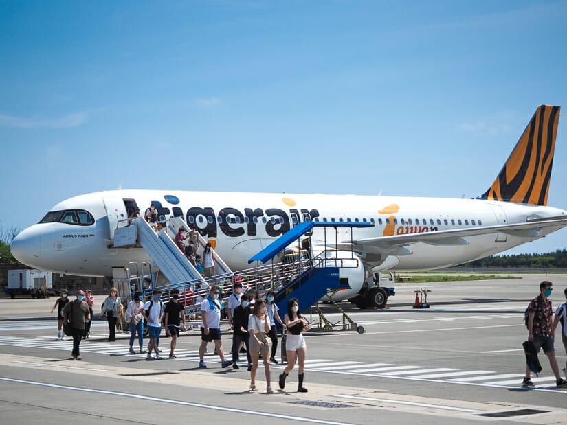 Passengers getting off an airplane at Penghu Airport from a plane that says Tigerair Taiwan on it