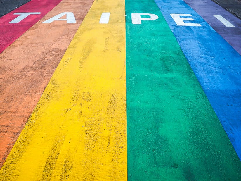 A large rainbow pride flag with the word "Taipei" in white on the street in Ximending neighborhood Taipei