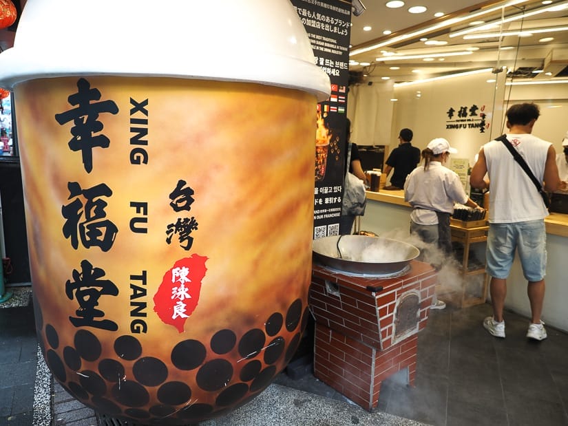 A huge bubble tea statue in front of a bubble tea shop