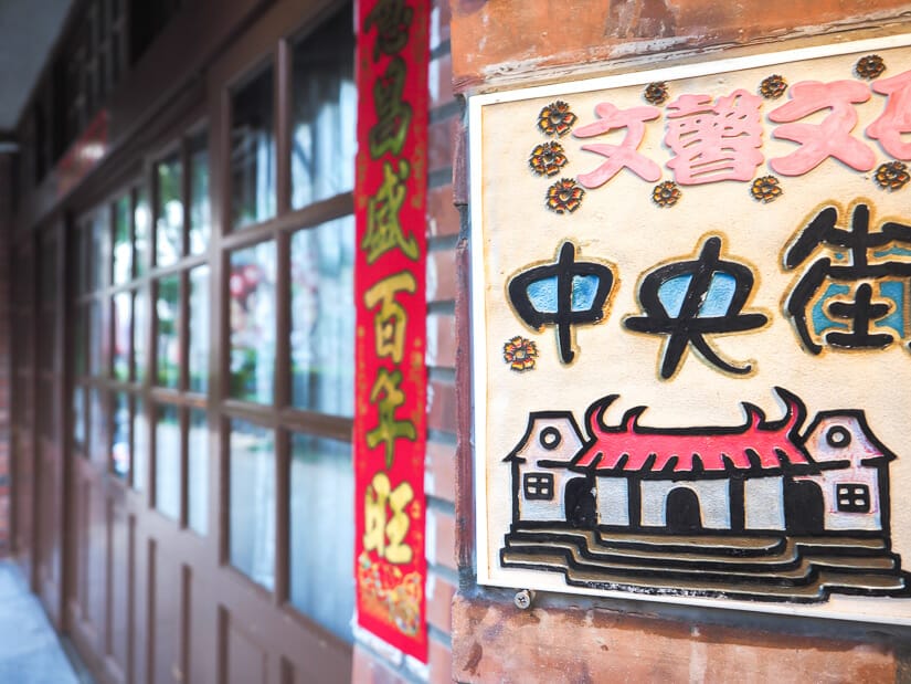 A sign that says Zhongyang Street in Mandarin and a sliding wooden door 