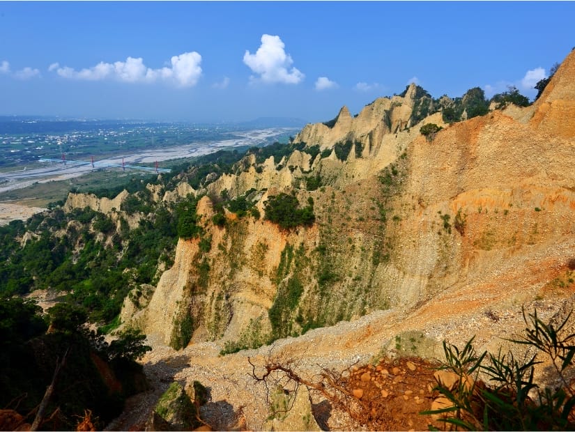 Looking down some red stone cliffs and a valley floor far below