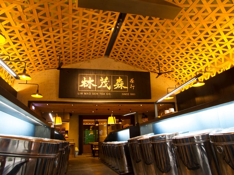 The interior of a tea company in Taipei with sign above that says Lin Mao Sen and many silver barrels of tea