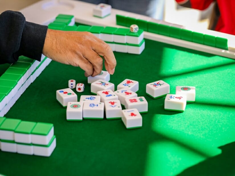 A hand grabbing a tile on mahjong board in Taiwan during chinese new year holiday
