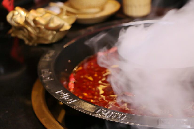 A steaming hot pot in Taipei with a dragon head on the side of the pot