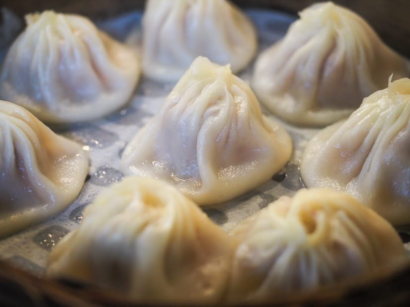 Close up of 8 xiaolongbao inside a steaming basket