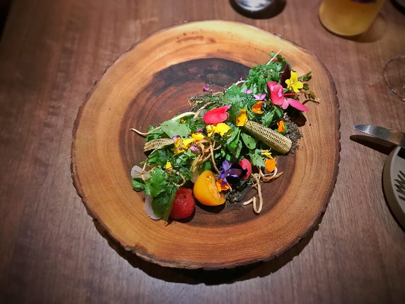 A fancy salad on a dark wood table at MUME restaurant Taipei