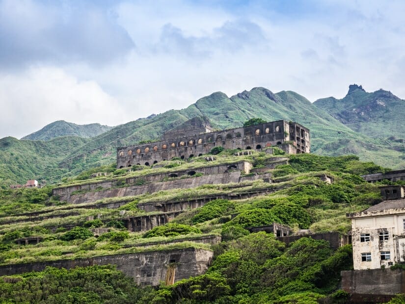 Looking up at the ruins of Shuinandong Smelter, or 13 Levels runs near Jiufen, with mountains behind