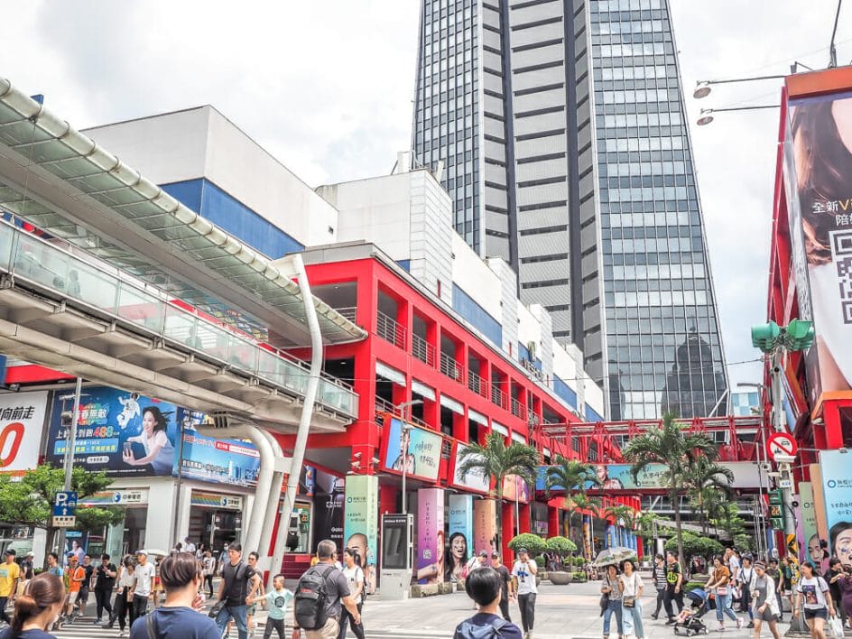 Shoppers walking down the street around Taipei 101 on a cloudy day