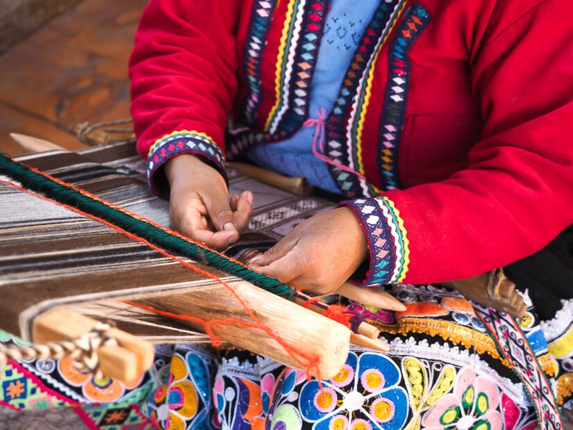 A close up of a Quechua woman doing weaving at Awana Kancha in Cusco region