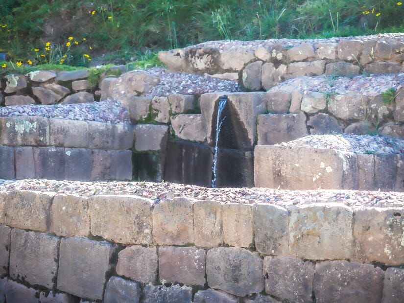 One of several stone ceremonial fountains at Pisac ruins, with water running through it