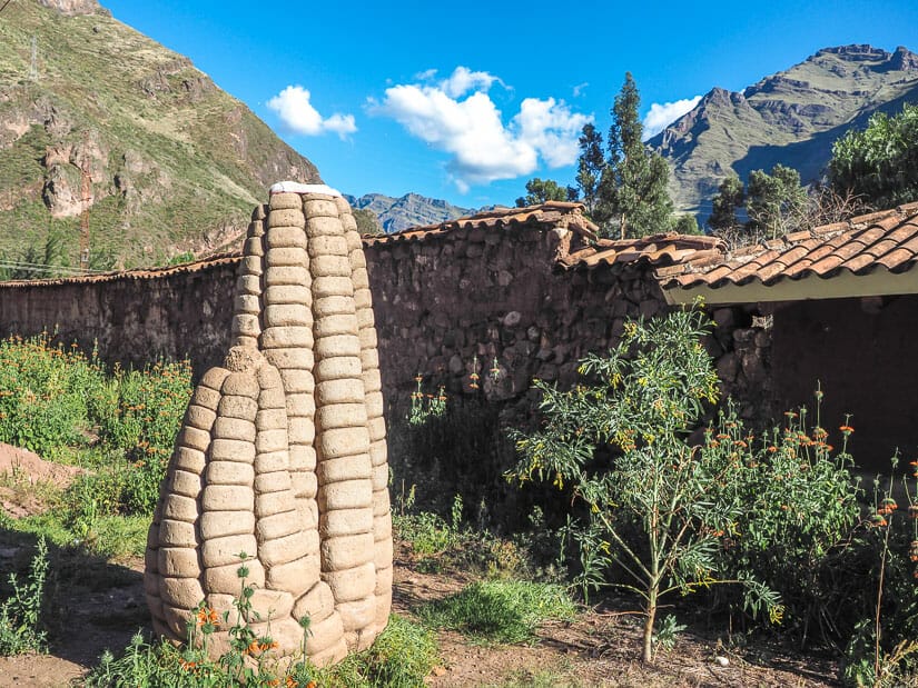 A statue of a corn cob outside of a corn farm in Pisac