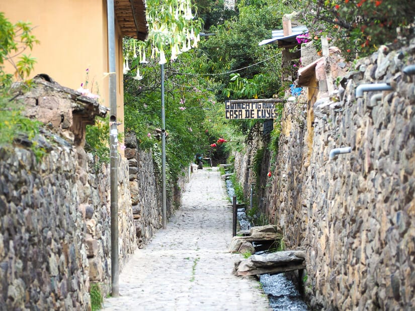 A stone alleyway with sign that says "Casa de Cuyes"
