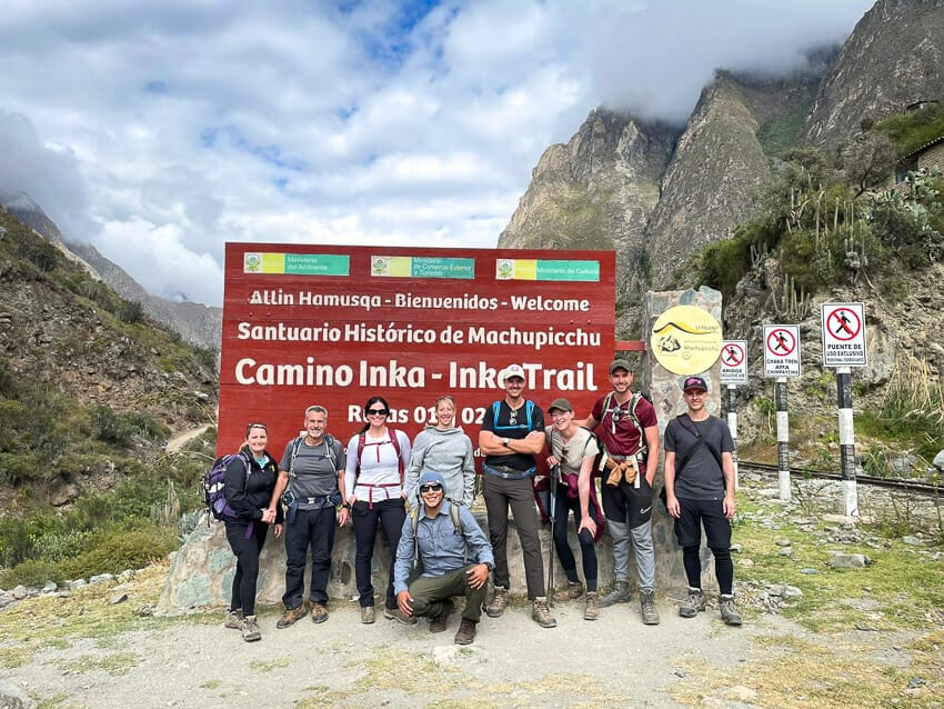 A group of hikers standing in front of a sign that says Camino Inka / Inca Trail