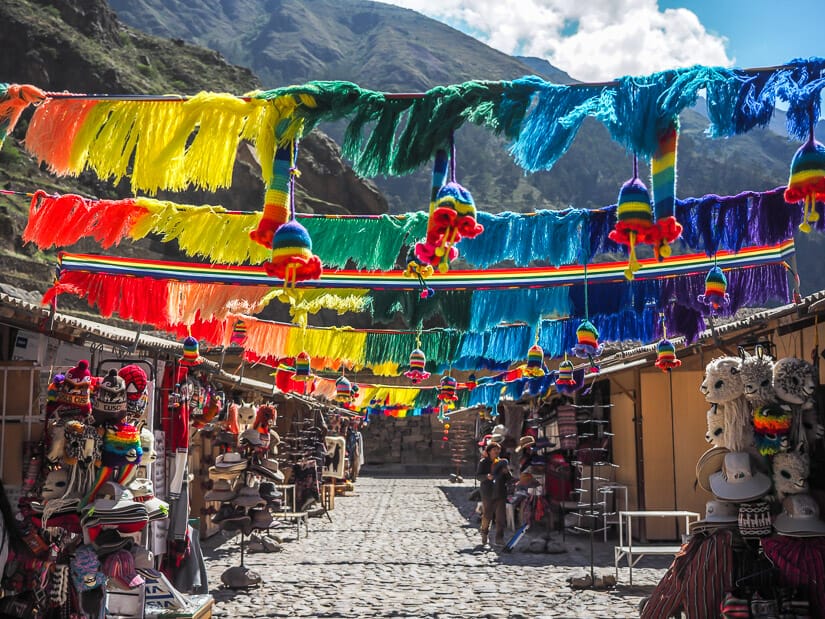 Some very colorful strings hanging over a tourist souvenir market in Ollantaytambo