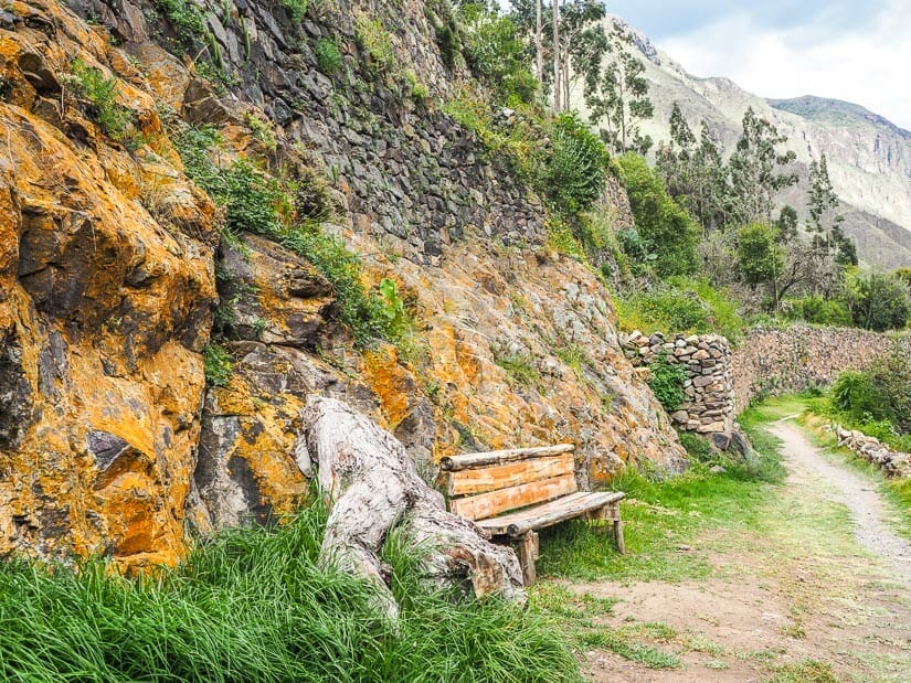 A bench with an Inca stone wall behind it