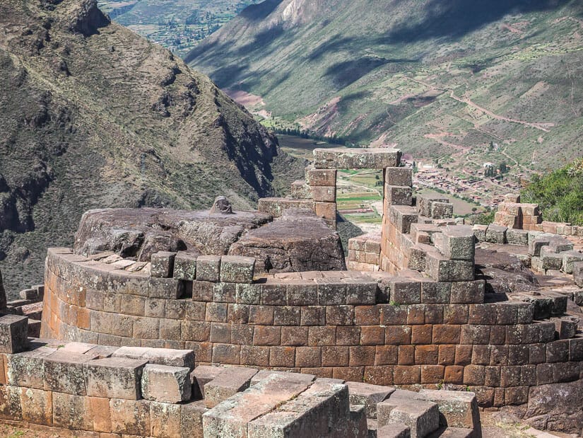 A round stone wall around the Inca Intihuatana at the ruins in Pisac with valley in background