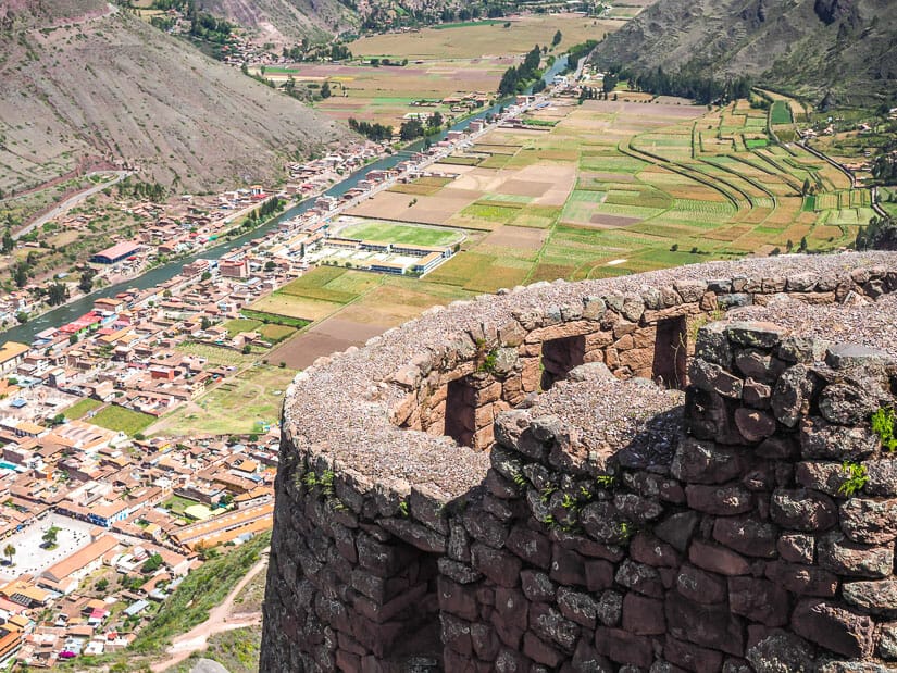 A stone watchtower with Pisac town visible far below