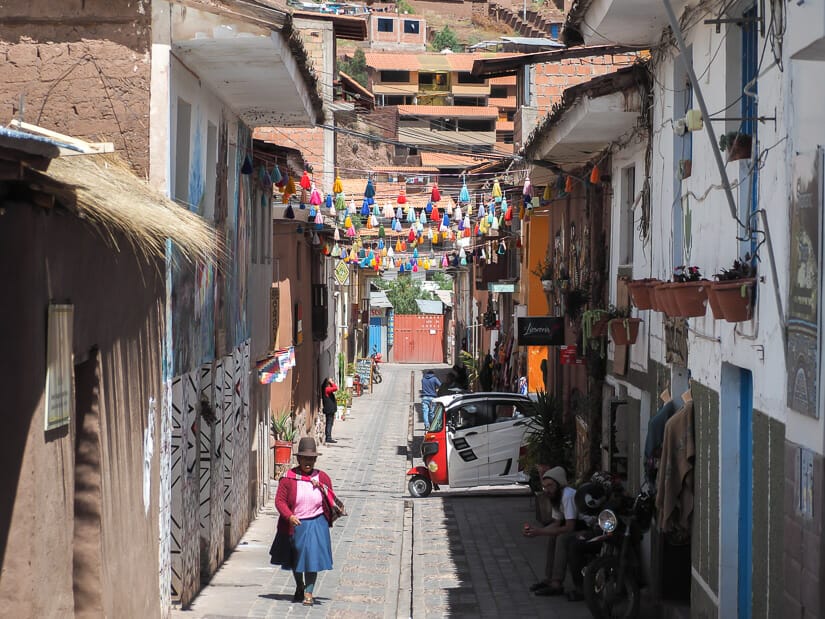 A local Quechua woman walking up a narrow street in Pisac