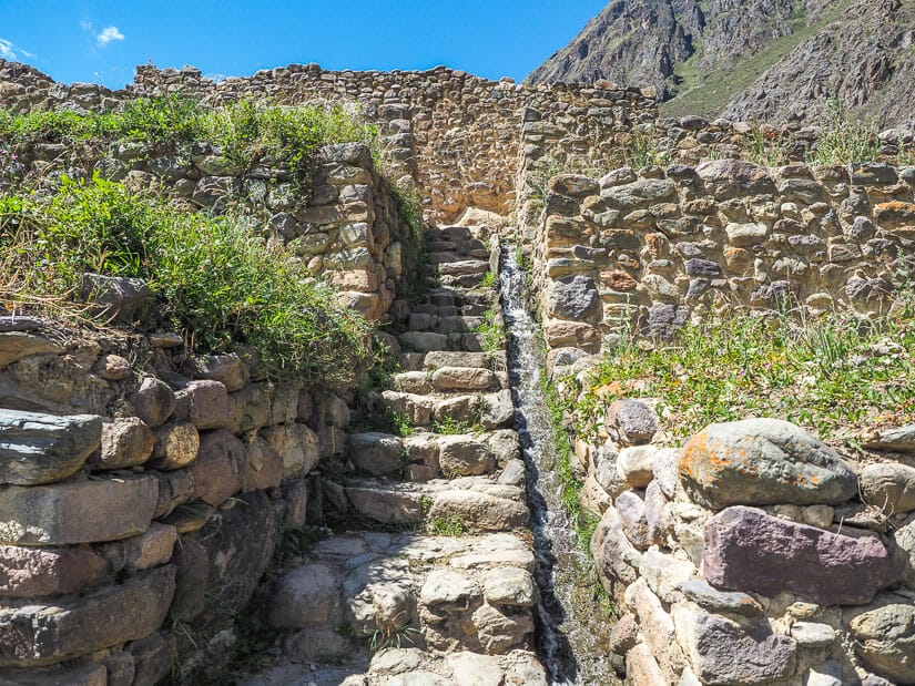 A stone staircase and water canal leading up to Qelloraqay ruins