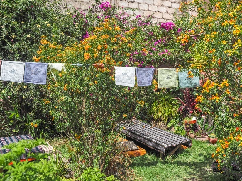 Outdoor seats in a garden with prayer flags hanging above