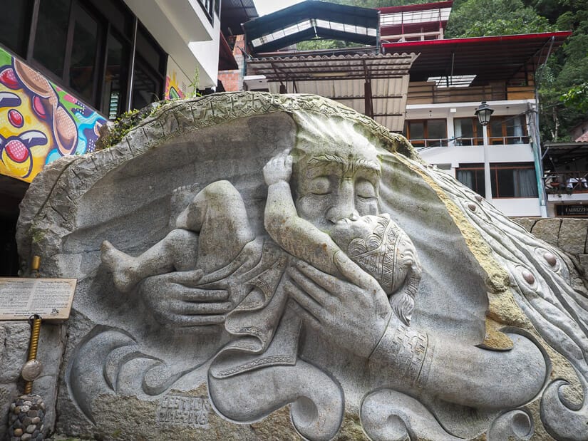 A stone carving of an old man kissing a baby