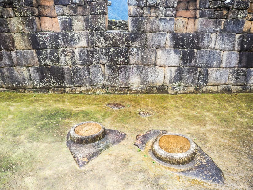 Two circular stone protrusions containing water on the House of Mirrors at Machu Picchu