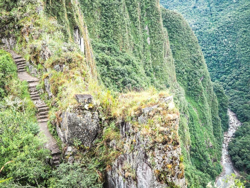 A steep stone staircase up Huayna Picchu, with a river visible far below on the right