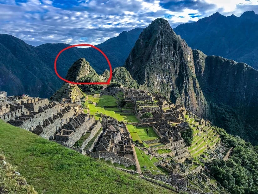 A classic postcard shot of Machu Picchu, with a small mountain called Huchuy Picchu circled in red