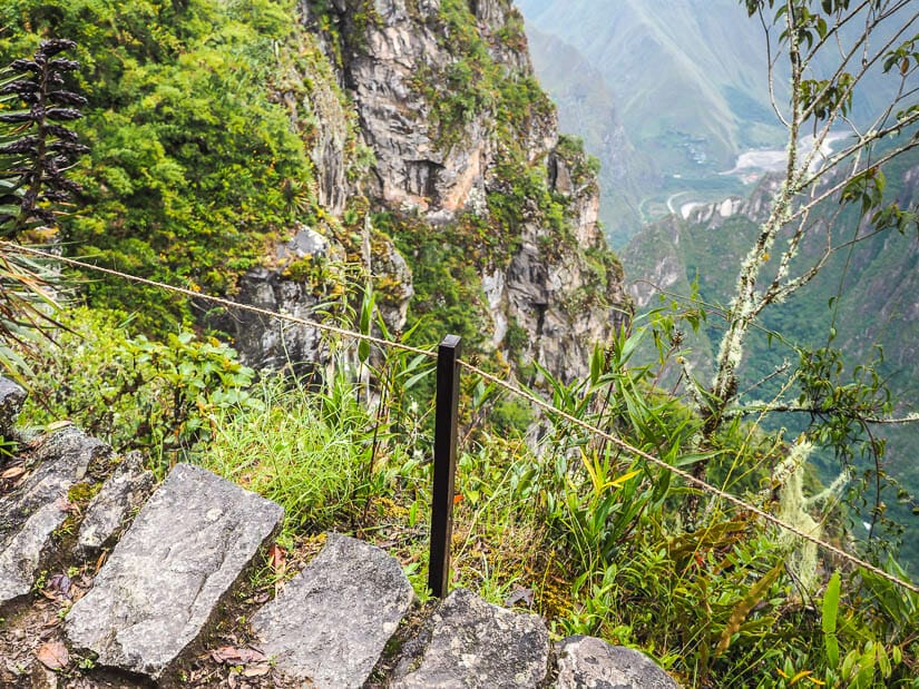 A fence made of a single rope on the edge of a stone trail on the hike to Inca Bridge