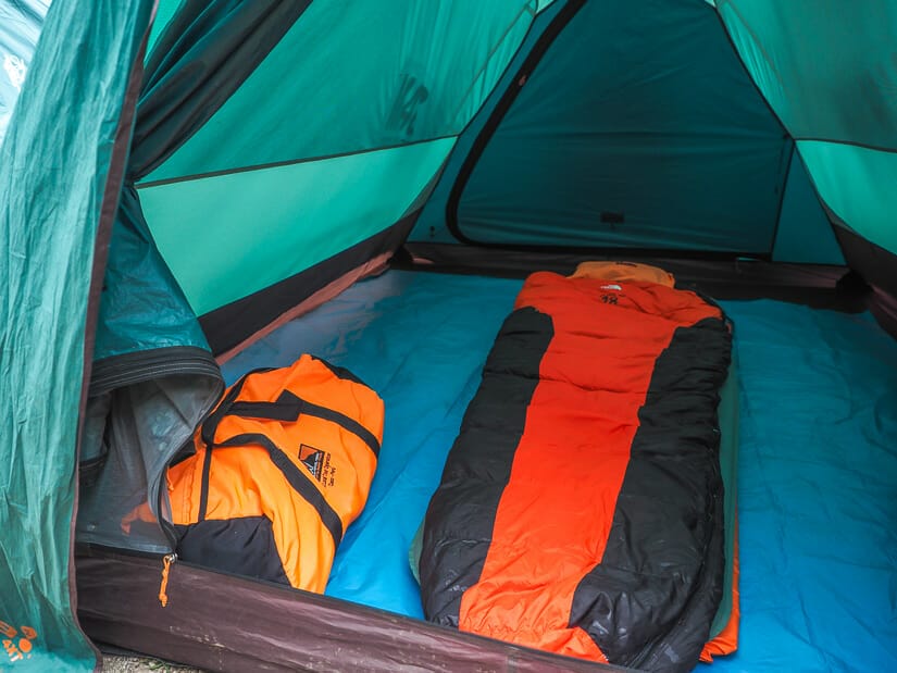 Close up of any orange sleeping bag and duffel bag inside a tent on at a camp on the Inca Trail