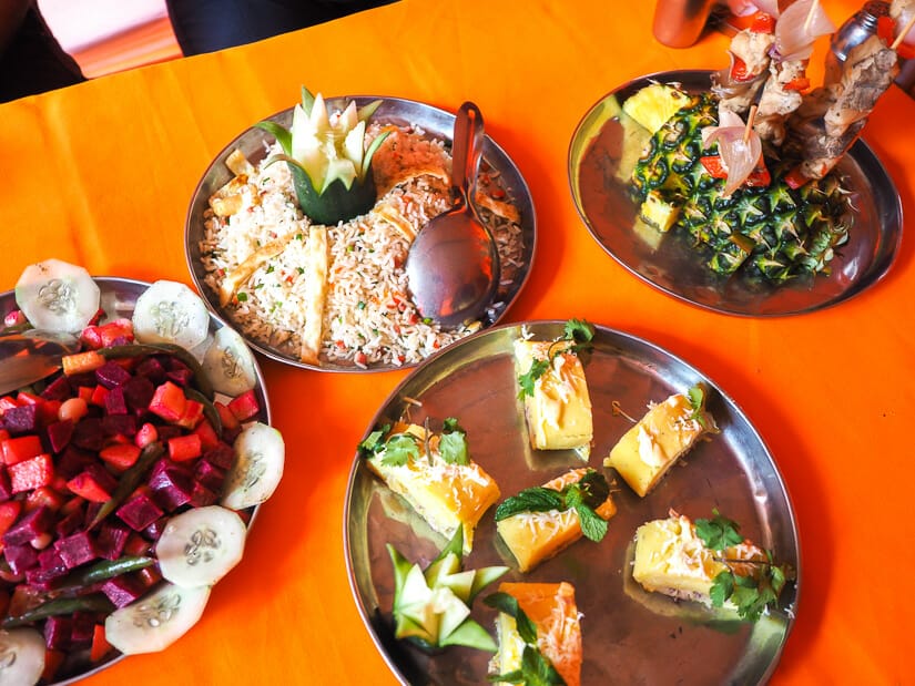 Close up of some plates of food on an orange table cloth in a dining tent on the Inca Trail.