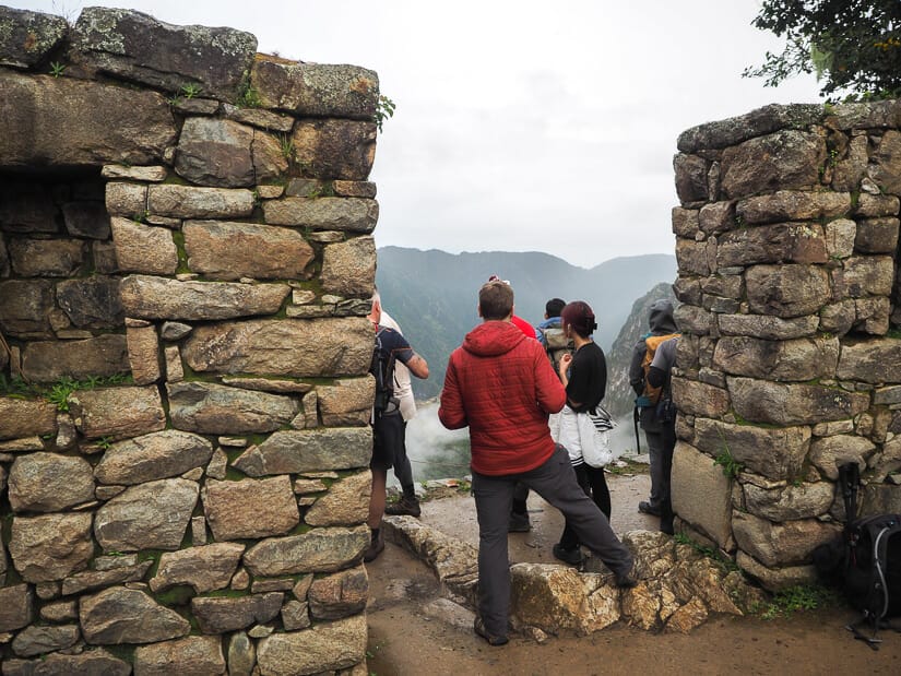 Some trekkers standing between a doorway at the Sun Gate