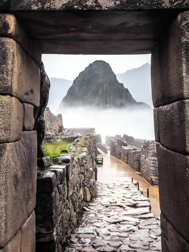 A stone door frame at Machu Picchu, which a pointy mountain perfectly framed in the distance