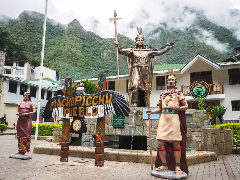 A statue of Pachucutec and Machu Picchu sign in the main square of Aguas Calientes