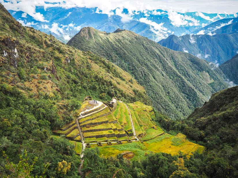 View of Phuyupatamarca ruins from above with mountains in background
