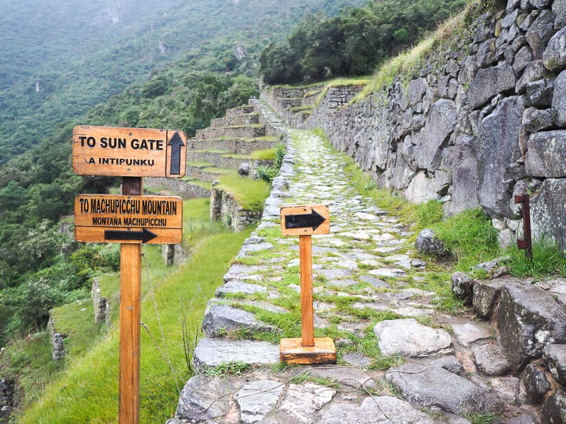 Signs with arrows on the Inca trail pointing the way to the Upper Viewing platform and Inca Bridge trail