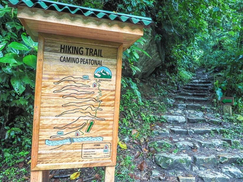A map and sign for the Machu Picchu hike with stone stairs on right