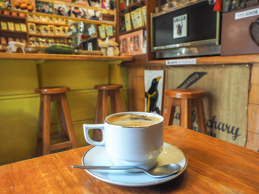 A white coffee mug on a wooden table, with cafe decor in background