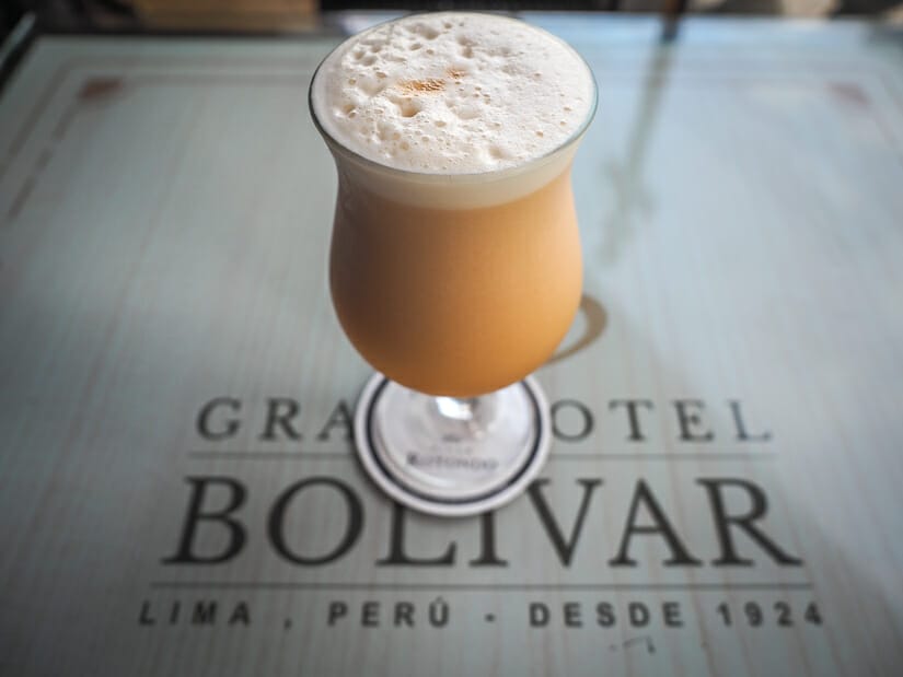 A brown colored cocktail on a table that says "Gran Hotel Bolivar"